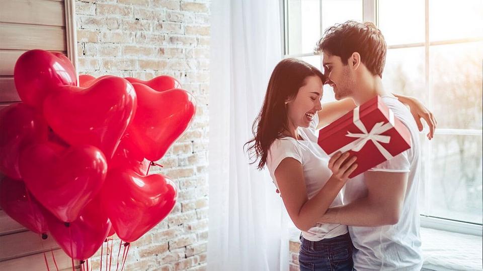 couple-cuddling-next-to-heart-shaped-balloons